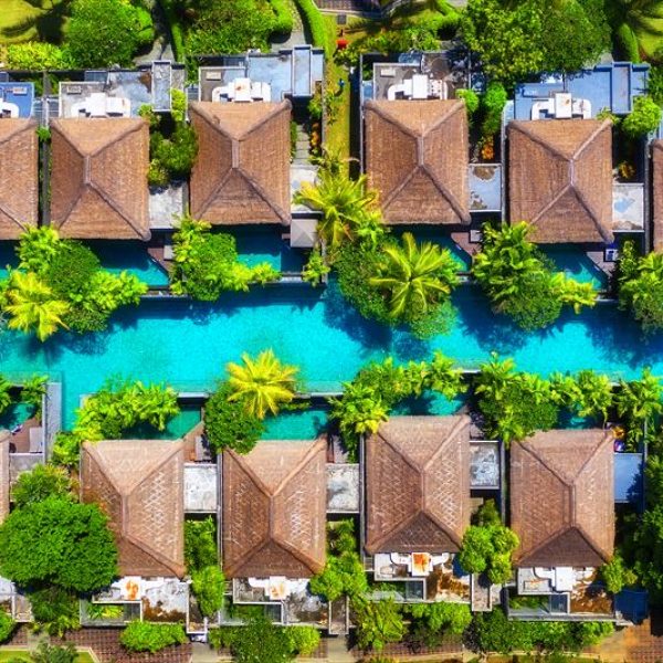 Air view of the villas and pool. Architecture in Bali, Indonesia. Landscape from the drone in the summer. Rest and relaxation.